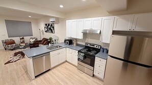 Una cocina moderna con gabinetes blancos, un refrigerador de acero inoxidable y una isla central.