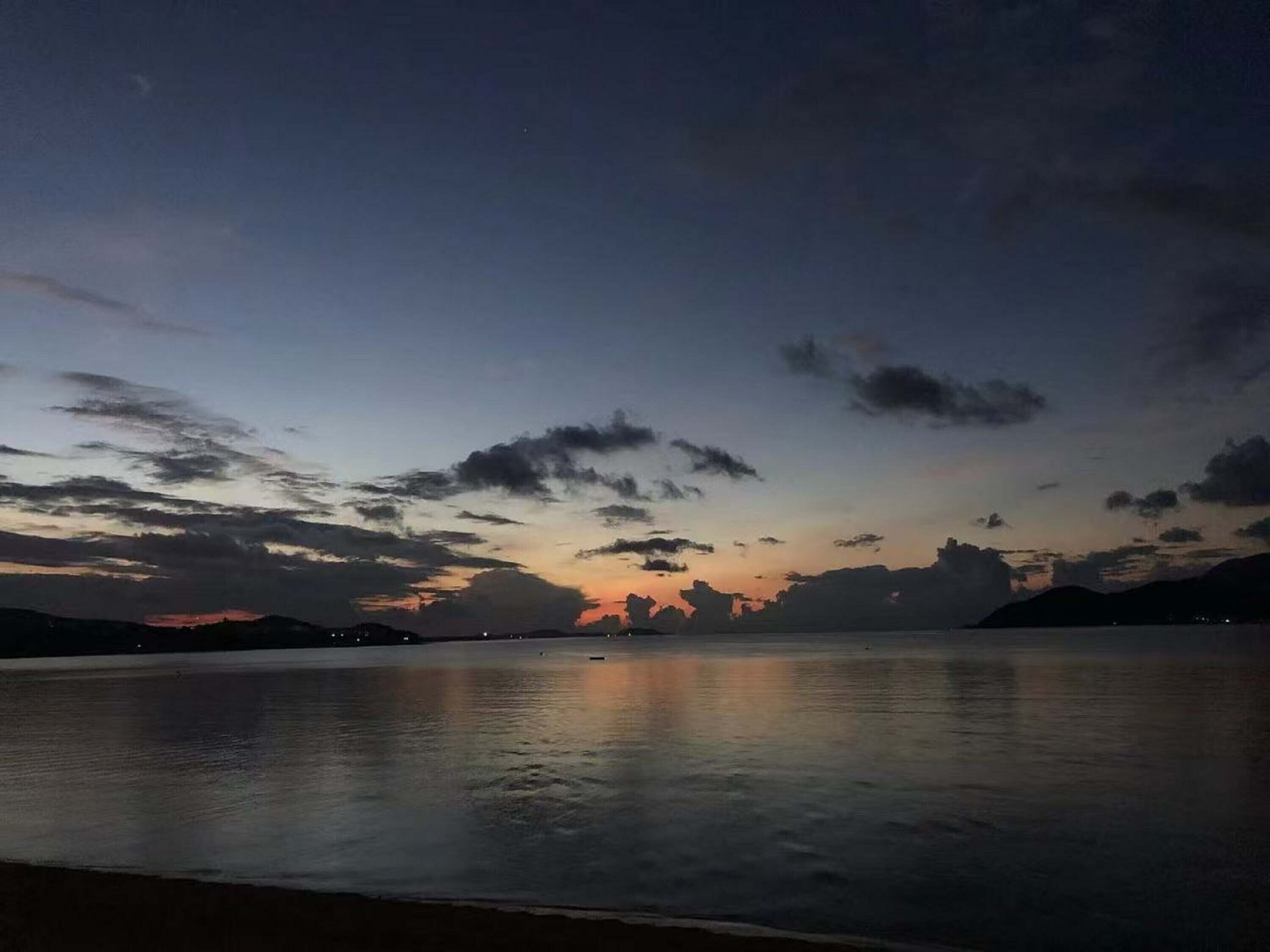 Un cuerpo de agua tranquila reflejando el cielo al atardecer.