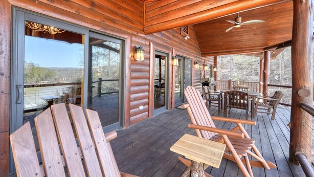 A wooden deck with outdoor seating, a ceiling fan, and a view of a natural landscape. -  Acorn Abbey - Lakeside Retreat w/3BRs, spring on the water! (Murphy)