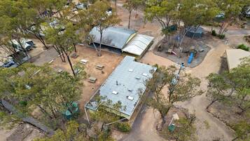 An aerial view of a campsite with tents, a covered area, and trees.