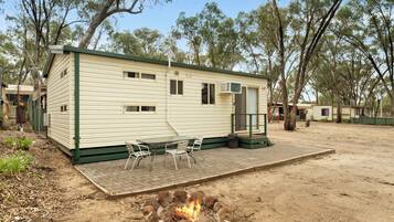 A mobile home with a patio area, a fire pit, and a small table with chairs.