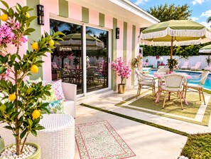 Eine Terrassenanlage mit Pool, Gartenmöbeln und Kübelpflanzen.