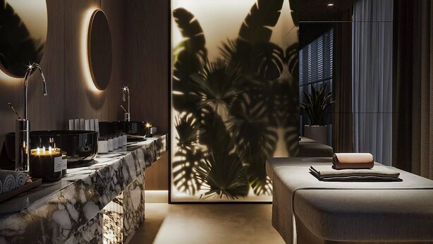 Ein modernes Badezimmer mit Waschtisch aus Marmor, einem großen Spiegel und einem wandmontierten Waschbecken.