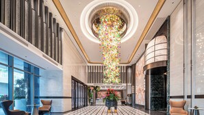 Eine großzügige Lobby mit hoher Decke, einem zentralen Chandelier und einem gemusterten Boden.