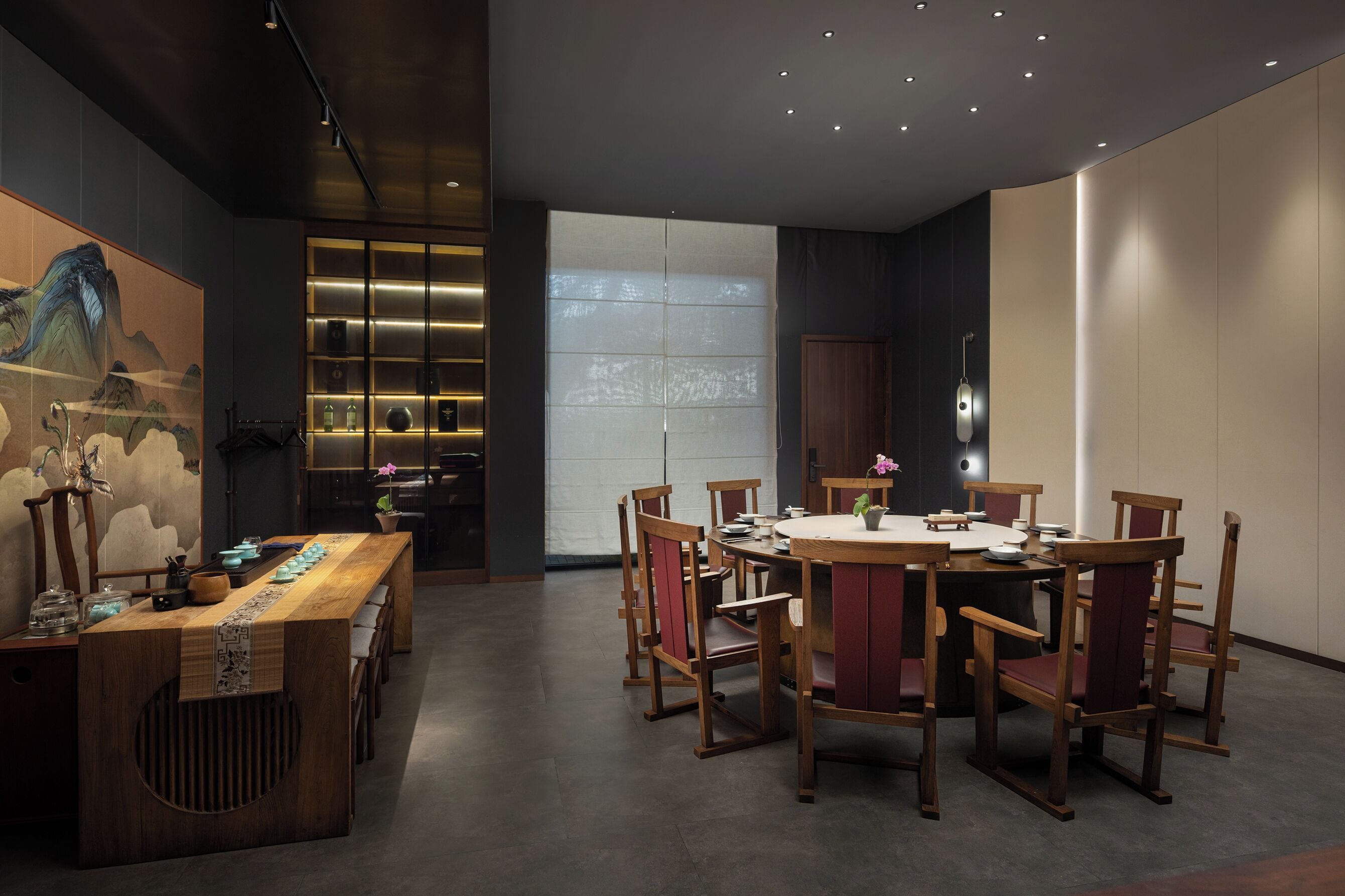 Un moderno comedor con una mesa y sillas de madera, un panel decorativo con arte tradicional, y un ventanal que proporciona luz natural.