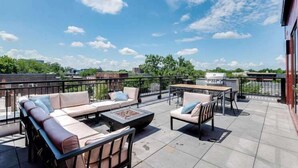 A rooftop terrace with outdoor seating, a barbecue grill, and a view of the city skyline. - 1 Bed Apt + Rooftop | Lake of Isles (Minneapolis)