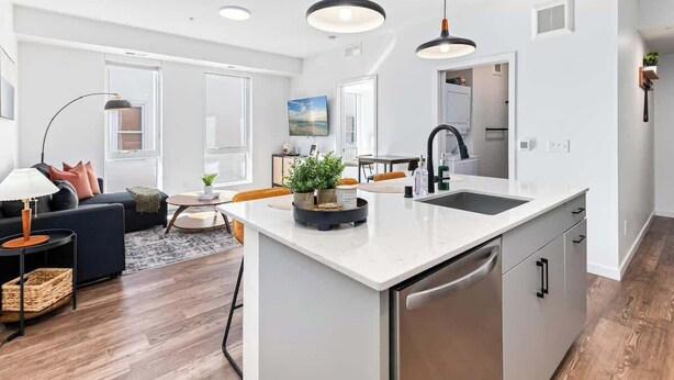 A modern kitchen with a central island, stainless steel appliances, and pendant lighting. - 1Bed Apt, Gym | Lowry Hill | Theater (Minneapolis)