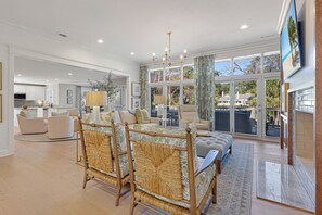 A spacious living room with a large sofa set, a dining area, and a kitchen in the background. - Family Getaway, Newly Renovated Sea Pines Oasis (Hilton Head Island)