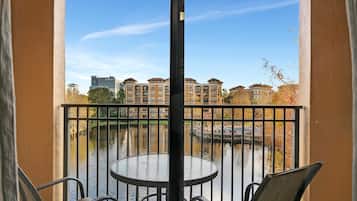 Een balkon met uitzicht op een gracht en gebouwen op de achtergrond.