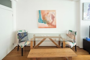 A modern living room with a glass-top coffee table, two patterned armchairs, and a colorful abstract painting on the wall. - Drury Lane - A Slice of Heaven (London)