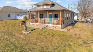 A single-story house with a porch, a blue door, and a small front yard. - The Bunkhouse | Downtown Branson Home Walkable to Landing & Convention Center (Branson)