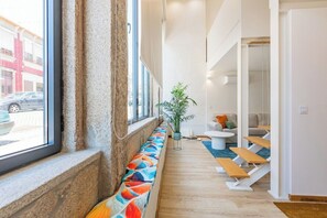 Ein Korridor mit einer Bank, einem Blumentopf und einer Sitzecke mit Sofa und Tisch.