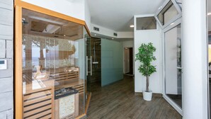 A modern interior with a wooden floor, a glass partition, and a potted plant. - Holiday apartment with wellness facilities and shared swimming pool (Novi Vinodolski)
