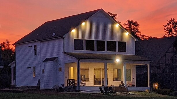 A two-story house with a large porch and a covered outdoor seating area. - “Room for Everyone: Seven-Bedroom Lakefront Getaway on Lake Tillery” (Norwood)