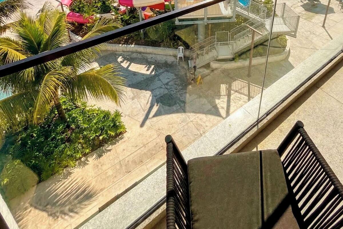 A resort with multiple swimming pools, a water park, and a view of the ocean.