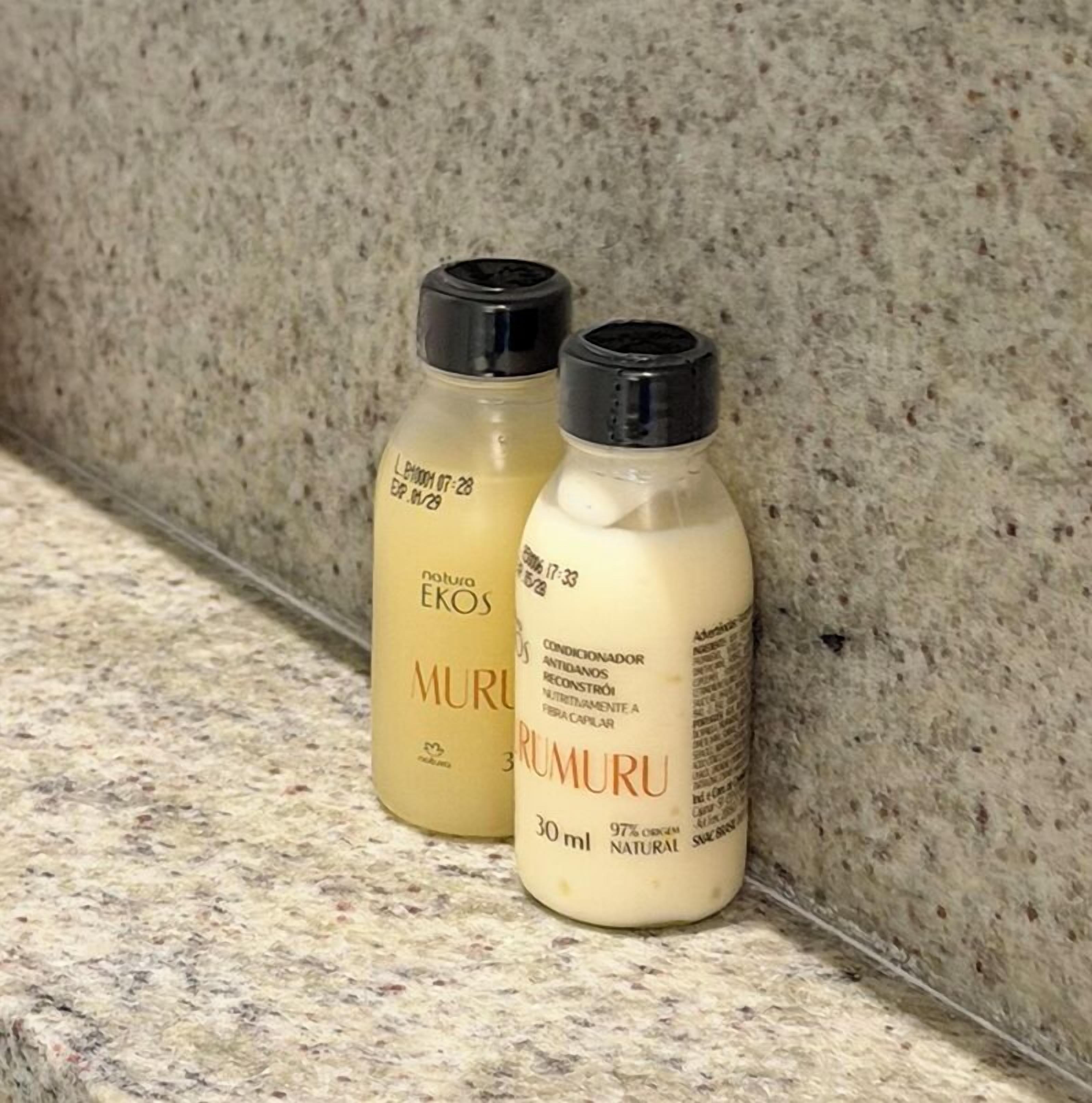 Deux flacons de produits de soins capillaires sont posés sur un comptoir en granit.
