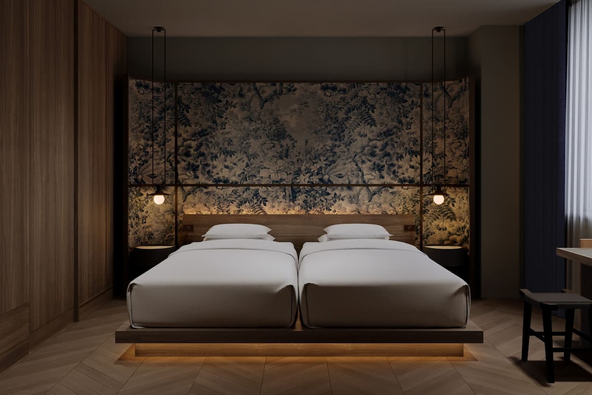 A modern bedroom with a large bed, two bedside tables, and a decorative wall panel.