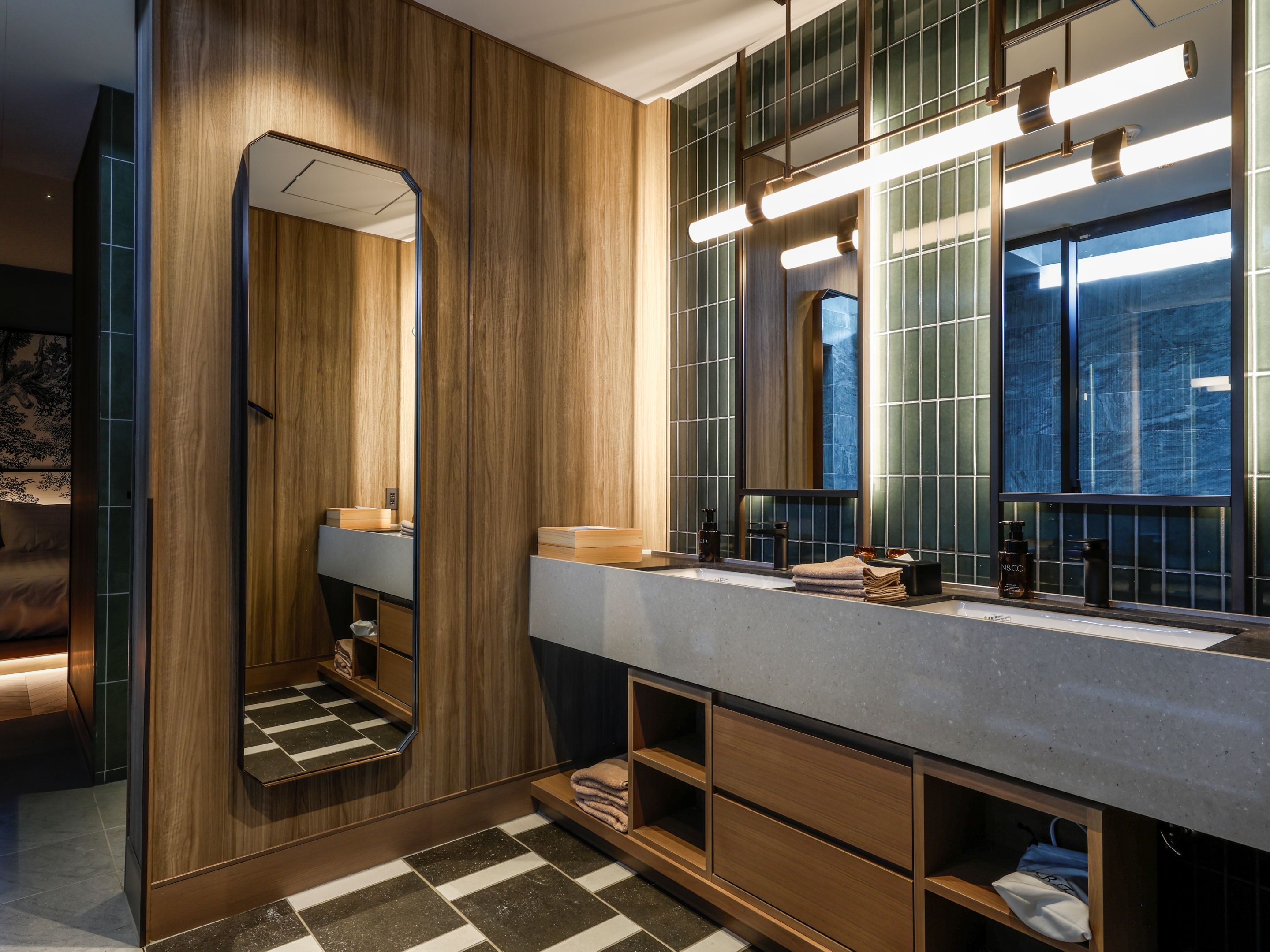 Ein modernes Badezimmer mit einem Holzbadezimmer-Möbelstück, einem großen Spiegel und einer eingebauten Ablagefläche.