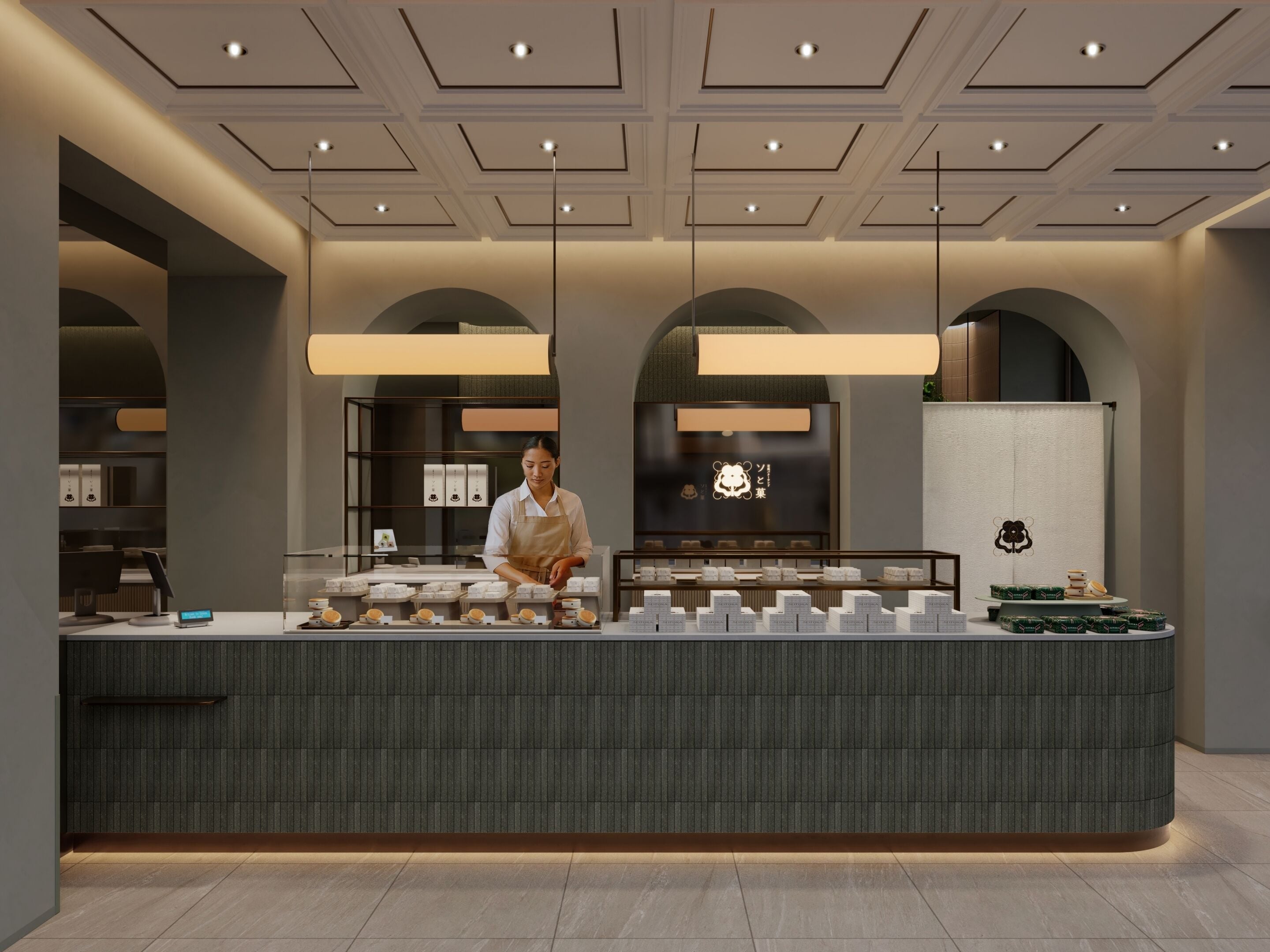 Una cafetería moderna con un mostrador central, una persona preparando comida y un logotipo en la pared.