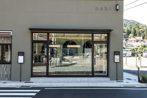 A modern building with a large glass storefront and a sign that reads 'nebi'. - Arima Hot Spring nebi (Kobe)