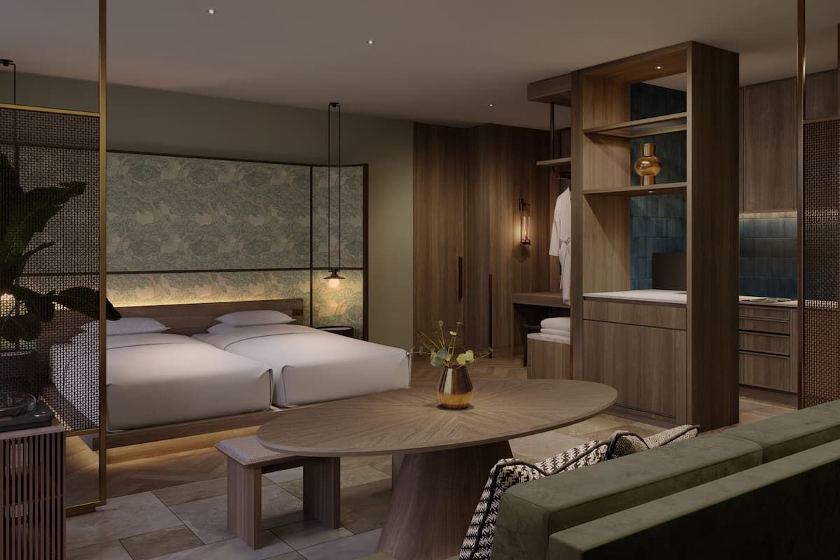 A modern bedroom with a bed, bedside tables, a round wooden table, and a decorative vase.