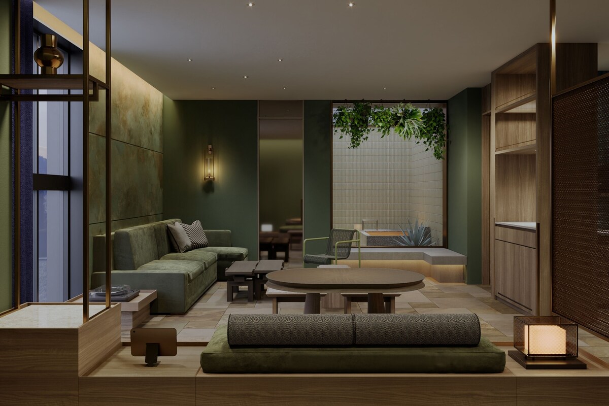 A modern living room with a green sofa, a round coffee table, and a dining area.