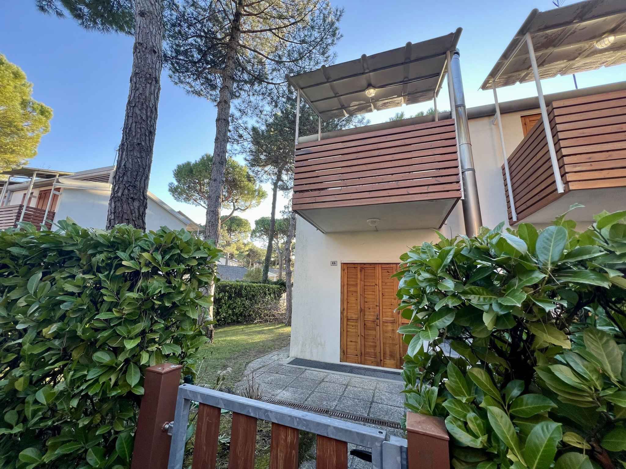 Un bâtiment moderne à deux étages, doté d’une porte en bois et d’un espace extérieur abrité.