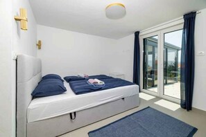 Ein Schlafzimmer mit einem Bett, einem Fenster und einer Deckenleuchte.