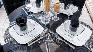 A round glass table with a black and white checkered table runner, black upholstered chairs, and clear glassware. - Luxury 2BR/2BA Modern B Apartment in Ajax, Toronto (Ajax)