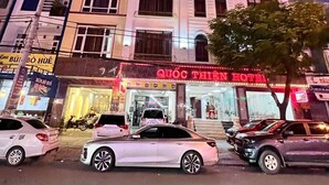 Egy többemeletes szálloda, melynek földszintjén feltűnő tábla hirdeti a „QUOC THIEN HOTEL” nevet.