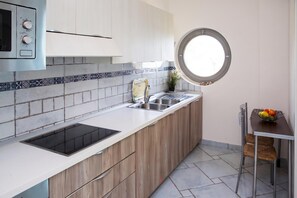 Eine moderne Küche mit Einbauofen, Spüle und Fenster.