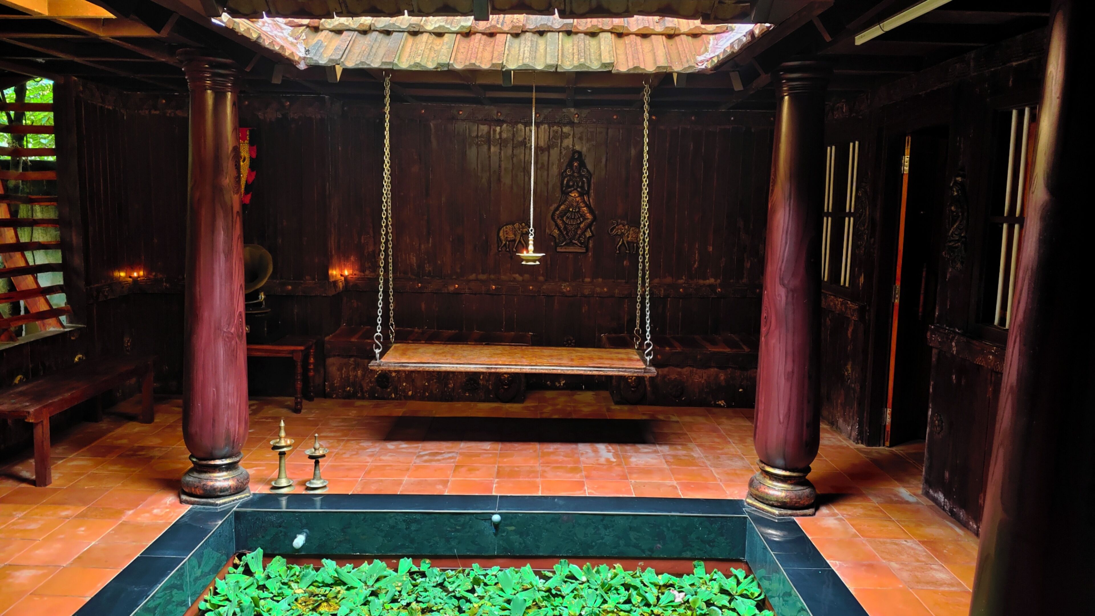 Une pièce à l’ambiance traditionnelle, avec une balançoire, une petite table et un élément décoratif aquatique.