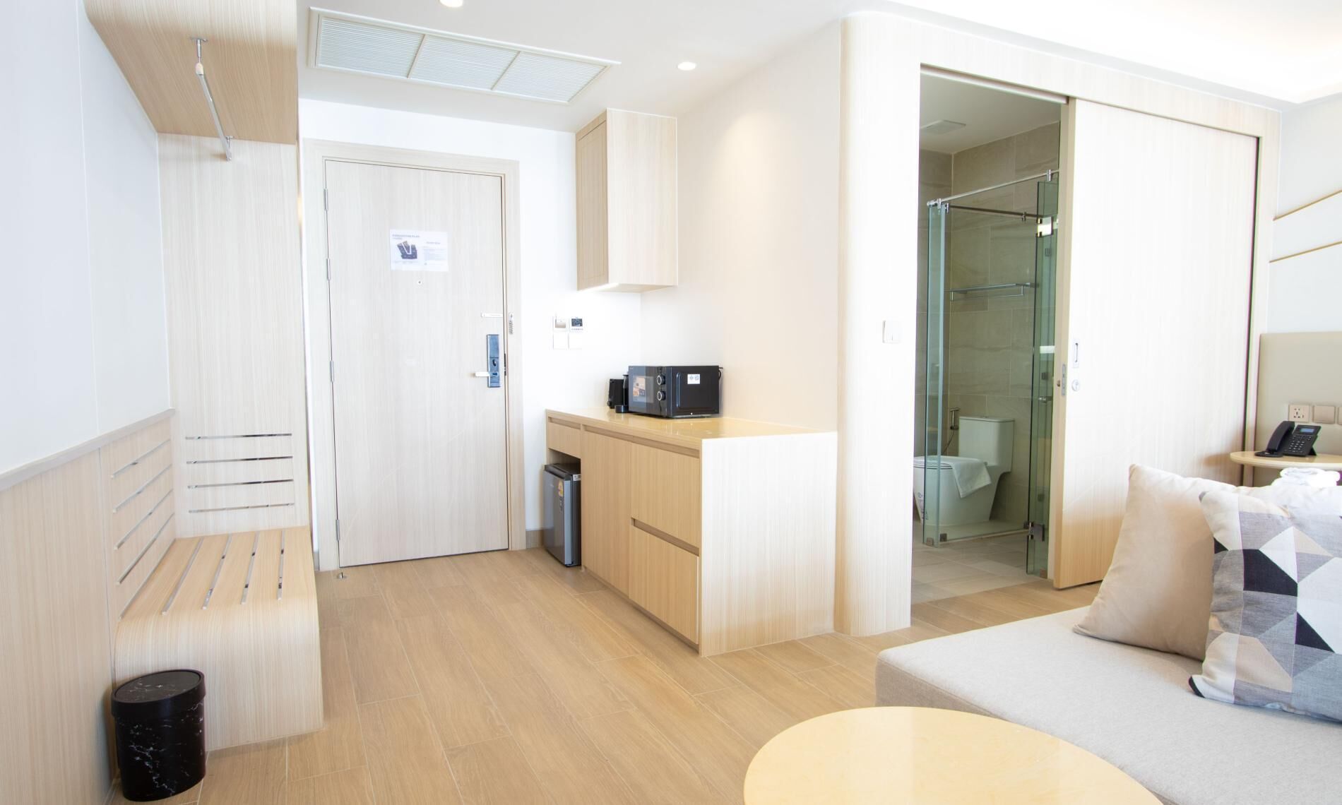 Bright entrance area with kitchenette, wooden finishes, and modern design.