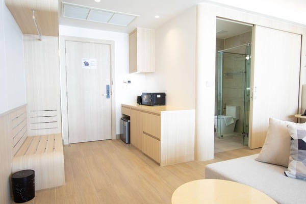 Bright entrance area with kitchenette, wooden finishes, and modern design.