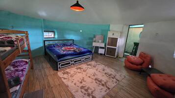 Een slaapkamer met een bed, bureau, stoel en een kledingkast.