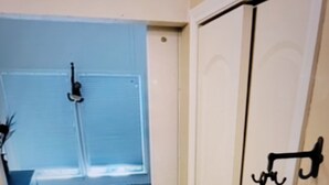 A narrow hallway leading to a bedroom with a bed, a small table, and a window. - In the trendy, funky & walkable South Congress area — 2-bedroom condo in Austin! (Austin)