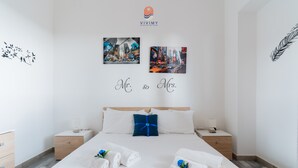 Ein Hotelzimmer mit einem großen Bett, zwei Nachttischen, einer Holzkommode und Bildern an den Wänden.