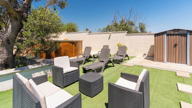 Eine Terrasse mit Gartenmöbeln, einem Pool und einem Holzschuppen.