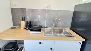 A kitchen with a sink, a coffee maker, and a toaster on a wooden countertop.