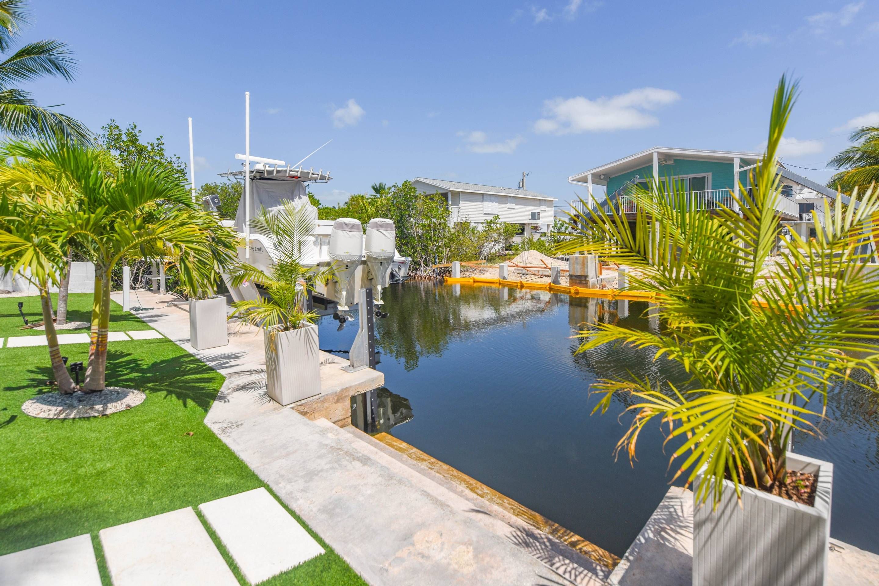 A pool area with a clear view of the surrounding landscape, including a building and palm trees.