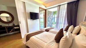A hotel room with two beds, a TV, a bathroom with a mirror, and a view of the outdoors. - Dealton Hotel Sanur (Denpasar)