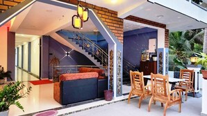 A modern interior with a staircase, seating area, and dining setup. - Green star villa (Jaffna)