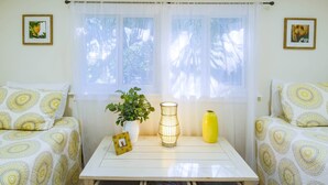 Una habitación acogedora con dos camas estampadas, una mesita con una planta, un florero y un marco de fotos.