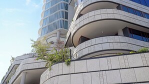 Ein modernes Gebäude mit mehreren Balkonen, großen Fenstern und einer geschwungenen Fassade.