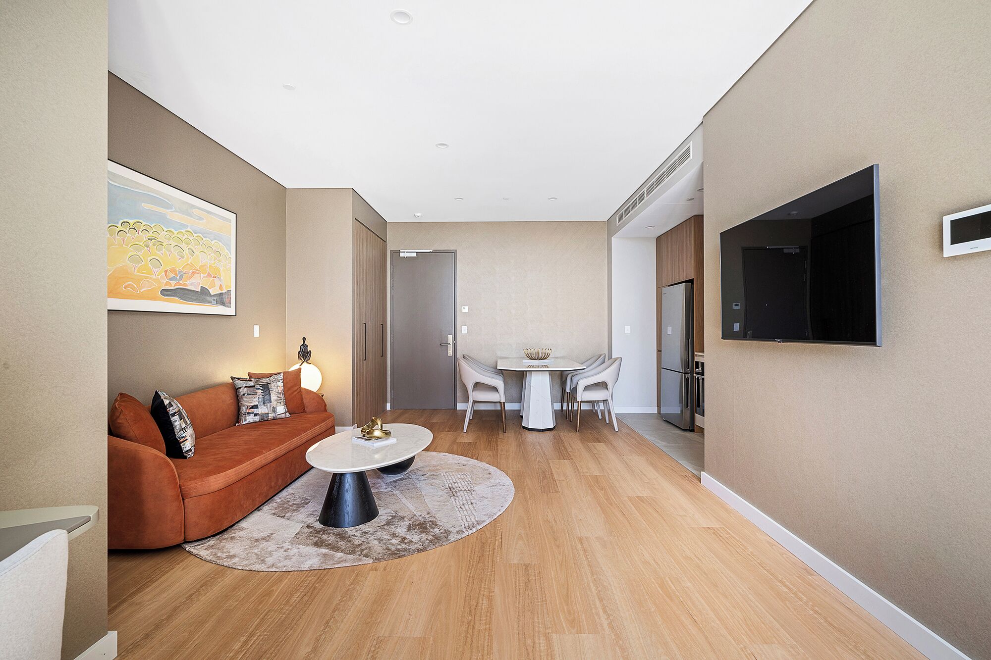 A modern living room with a sofa, coffee table, and dining table.