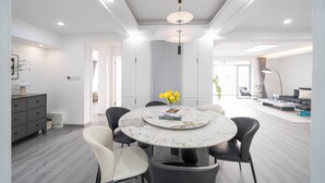 Un comedor moderno con una mesa redonda, sillas negras y una encimera de mármol blanco.