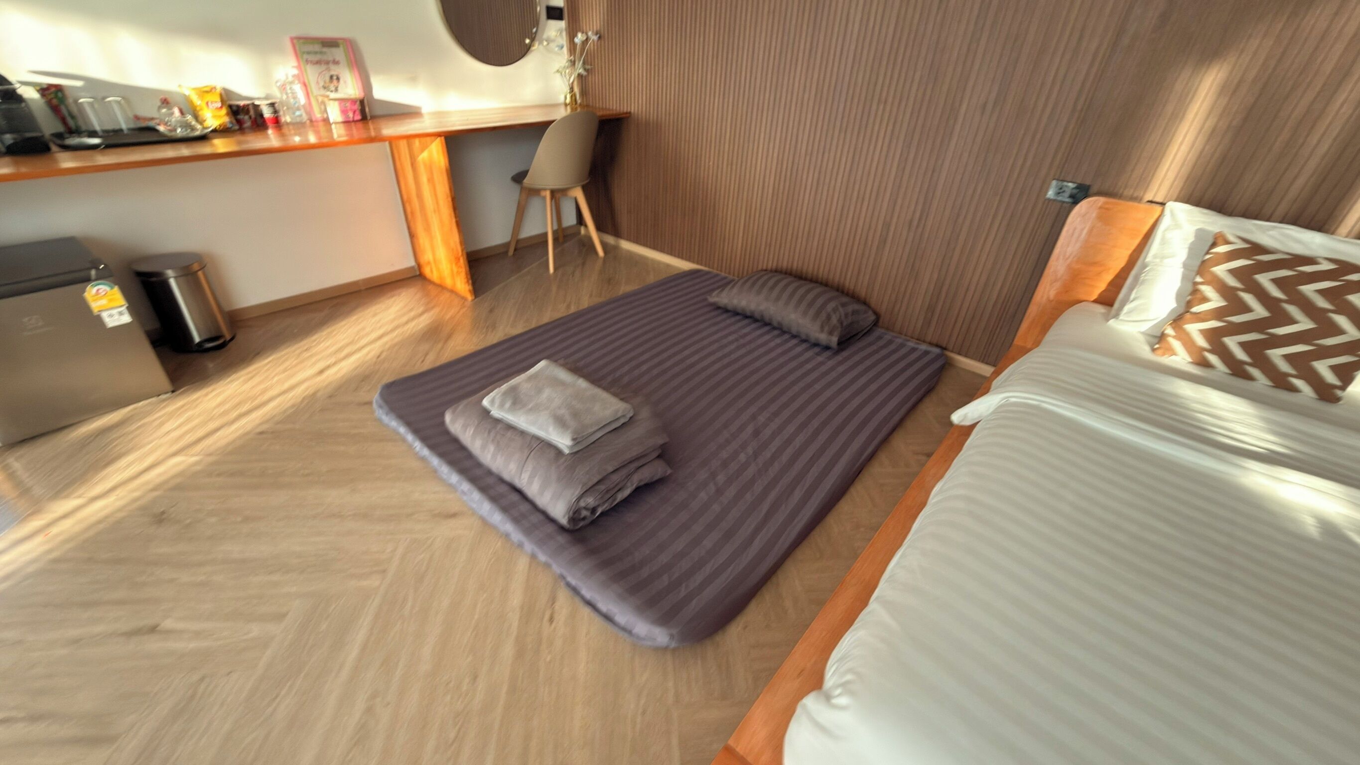 Une chambre d’hôtel de taille réduite, comprenant un lit, un bureau et une chaise.