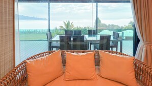 Una habitación con un ventanal grande que da a una terraza con mobiliario exterior.