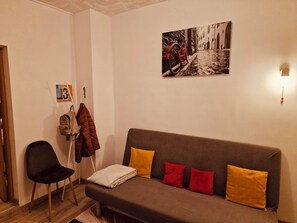 A cozy room with a sofa, a chair, and a coat rack. - Cosy apartment in a city centre Brasov (Brașov)
