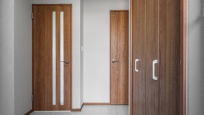 A hallway with wooden doors and a tiled floor. - HILLS NISEKO C (Niseko)